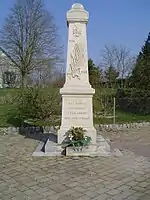 Photographie en couleurs d'un monument mémorial et de la place qui l'entoure.