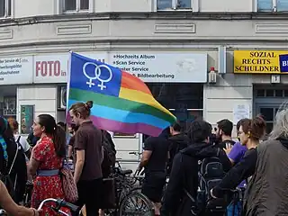 Drapeau LGBT sur lequel s'ajoute les symboles de Vénus entrelacés, Berlin, 2018.