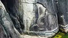 Au-dessus de l'eau, la tête d'un éléphant en léger bas-relief lève sa trompe finement sculptée.