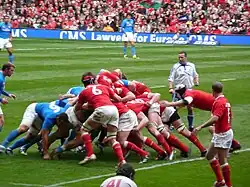 Photographie d'une mêlée dans un match de rugby à XV, entre l'équipe d'Italie en maillots rouges et l'équipe d'Italie en maillots bleus