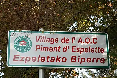 Panneau à l'entrée du village - Appartenance à l'AOC piment d'Espelette.