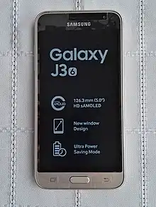un téléphone couleur doré, avec écran allumé