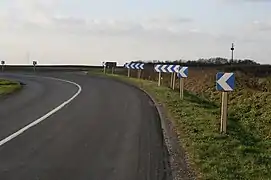 Ne pas mélanger les types de balises J4 dans un même virage. Dans le cas présent des balises J4 monochevrons côtoient des balises J4 à quatre chevrons, alors qu'il faut choisir selon le niveau de dangerosité : des monochevrons ou des trichevrons.