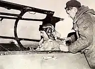 Homme coiffé d'un casque, assis dans le cockpit d'un avion militaire.