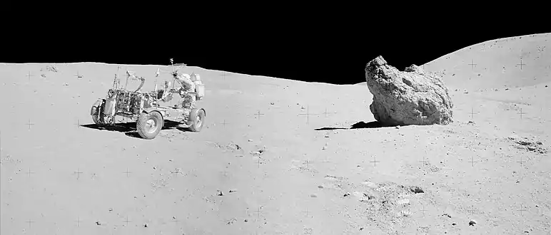 Mission Apollo 16 : durant sa troisième sortie sur le sol lunaire, John Young modifie l'orientation de l'antenne installée sur le rover lunaire.