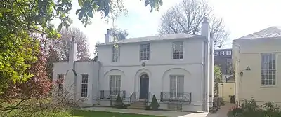 Belle maison double de style georgien modernisé, peinte en blanc, dans parc arboré