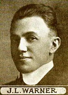 Portrait noir et blanc d'un homme avec un bandeau indiquant son nom.