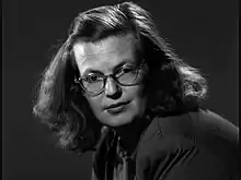 photo noir et blanc d'une femme aux cheveux longs avec des lunettes