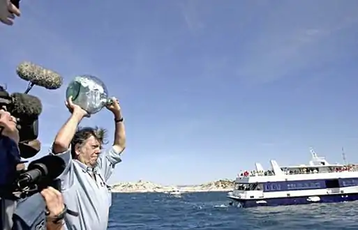 Marseille, le 5 juin 2005 : Jacques Amalric, alors journaliste à Libération, lance à la mer une bouteille contenant 150 messages de solidarité écrits par des célébrités et des anonymes afin de manifester son soutien à la journaliste Florence Aubenas et à son fixeur irakien Hussein Hanoun al-Saadi, pris en otage depuis 150 jours en Irak.