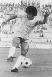 photo en noir et blanc d'un footballeur armant un tir
