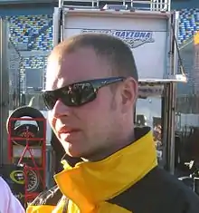 Photo d'un homme en veste jaune et portant des lunettes de soleil