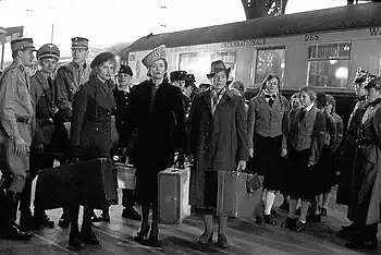 Photo en noir et blanc, montrant des acteurs du film Julia devant un train stationné en gare.