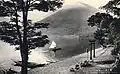 Photo noir et blanc d'une montagne au bord d'un lac, avec au premier plan, un portail traditionnel de sanctuaire shinto.