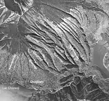 Photo noir et blanc de longues et larges entailles rocheuses le long d'un versant de volcan.