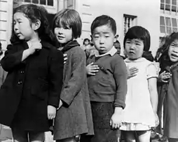 En avril 1942, des enfants de l’école publique de Weill, à San Francisco, prêtent allégeance au drapeau américain avant leur internement.