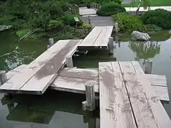 Un pont croche au jardin japonais.