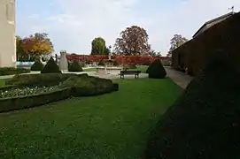 Vue de buis taillés en cônes et d'une fontaine.