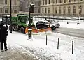 Un véhicule déneigeant la chaussée, quai des Tuileries.