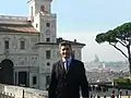 Photographie en couleurs d'un monsieur devant un paysage urbain