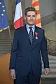 Un homme en costume décoré de l'insigne de chevalier de la Légion d'honneur.