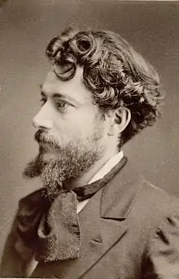 Photographie noir et blanc en buste d'un homme de profil portant moustache et cravate avec un foulard noué.