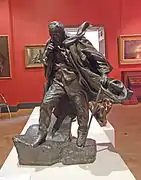 Bronze d'un homme marchant avec sa canne face au vent.