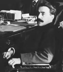 Jean Prévost de profil, assis sur une chaise.