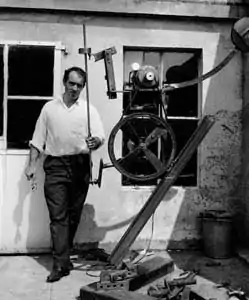 L'assemblage: Jean Tinguely devant son atelier avec un assemblage en cours. 1963. Photo Erling Mandelmann