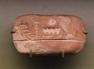 Petite tablette en argile comprenant des signes proto-cunéiformes et numériques.