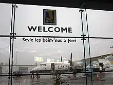 Panneau d'accueil bilingue anglais et normand à l'aéroport de Jersey.