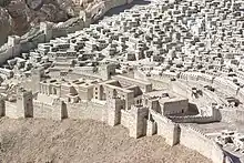 Vue d'une ville construite à flanc de colline entourée de remparts