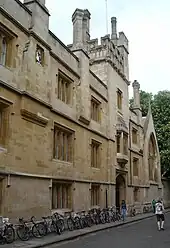 Un bâtiment de trois étages surmonté d'une tour, beaucoup de bicyclettes sont posées contre le mur