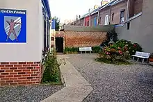 Photo d'un espace urbain, au centre un parterre de fleurs, entouré de bancs.