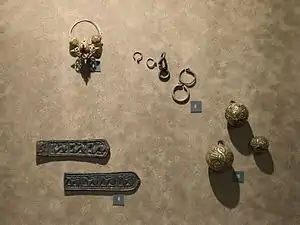 Les bijoux de la période slave : (8) boucle de ceinture en bronze, trouvé à Prague lors de la démolition des murs de la ville. (9) Anneaux de temple en argent et en bronze provenant d'un cimetière à Praha Motol. Bijoux typiquement slaves. (10) Boutons de gombik dorés provenant de Žalov près de Roztoky. (11) Boucle d'oreille en or de Žalov près de Roztoky. Le musée de la ville de Prague.