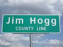 Un panneau de signalisation routière, vert sur fond blanc, indiquant la frontière du comté