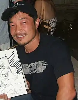 Un homme avec une casquette et un dessin à la main.