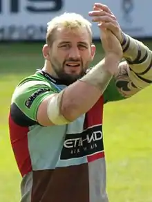 un homme en maillot de sport applaudissant