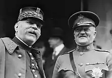 Photographie noir et blanc de deux hommes en habit militaire souriant.