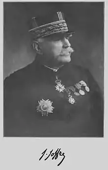 Photographie noir et blanc d'un homme moustachu en uniforme militaire (de nombreuses médailles sont visibles sur son torse) et sa signature sous la photo.