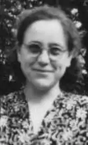Photo noir et blanc d'une jeune femme souriante, brune, en buste