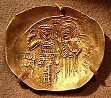 Photographie de la face d'une pièce de monnaie, représentant le buste de deux hommes.