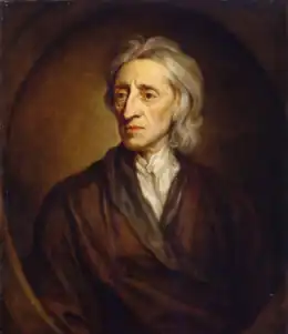 Portrait d'un homme aux cheveux blancs qui porte une large robe brune et une chemise blanche.