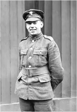 Portrait en noir et blanc d'un soldat en uniforme portant une casquette, les mains derrière le dos