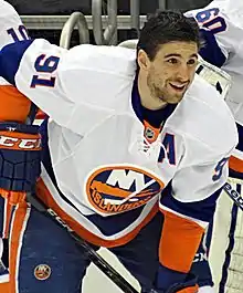Photographie d'un joueur de hockey avec un maillot de hockey et sans casque.
