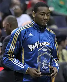 John Wall, portant une veste des Wizards, recevant un trophée.