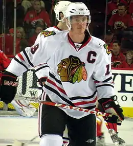 Photographie de Jonathan Toew dans le maillot blanc des Blackhawks et portant le C de capitaine.