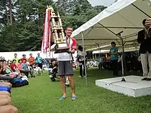 Jonathan Wyatt soulevant le trophée de la course du Mont Fuji.