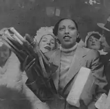Joséphine Baker tenant des poireaux lors d'une distribution de pot-au-feu en 1935. Le poireau peut faire partie de ce plat.