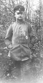 Josef Grüner, ami de Rudolf Berthold, debout, en uniforme, les mains dans les poches. L'arrière-plan est une forêt