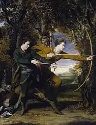 Deux jeunes hommes habillés de manière médiévale, tirant à l'arc dans les bois.
